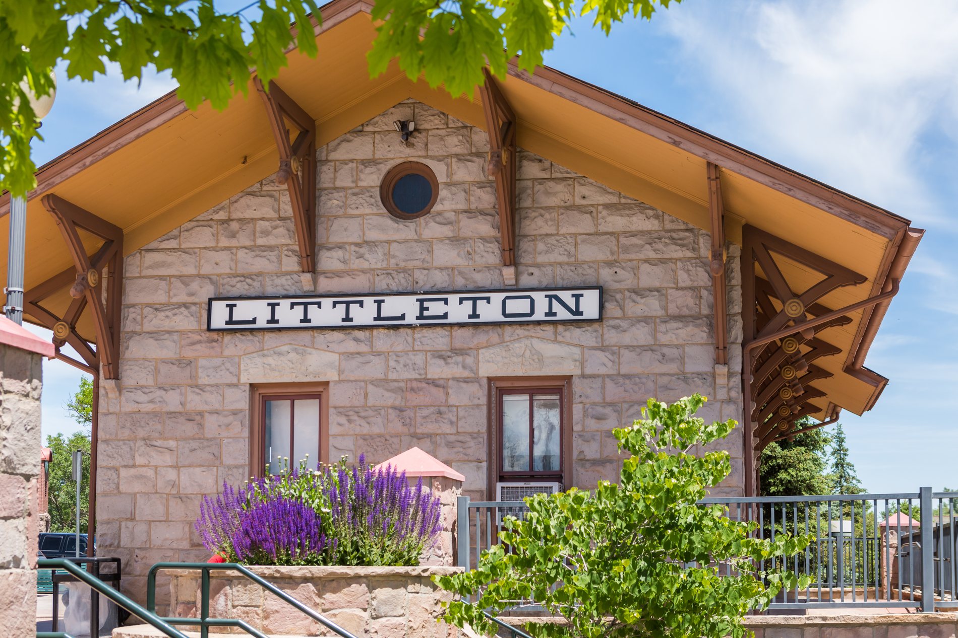 The historic stone Littleton depot at the Downtown Littleton light-rail station, its name painted under the eaves.