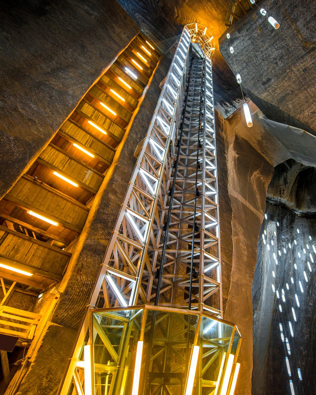 A lit headframe and gantry deep inside a working mine